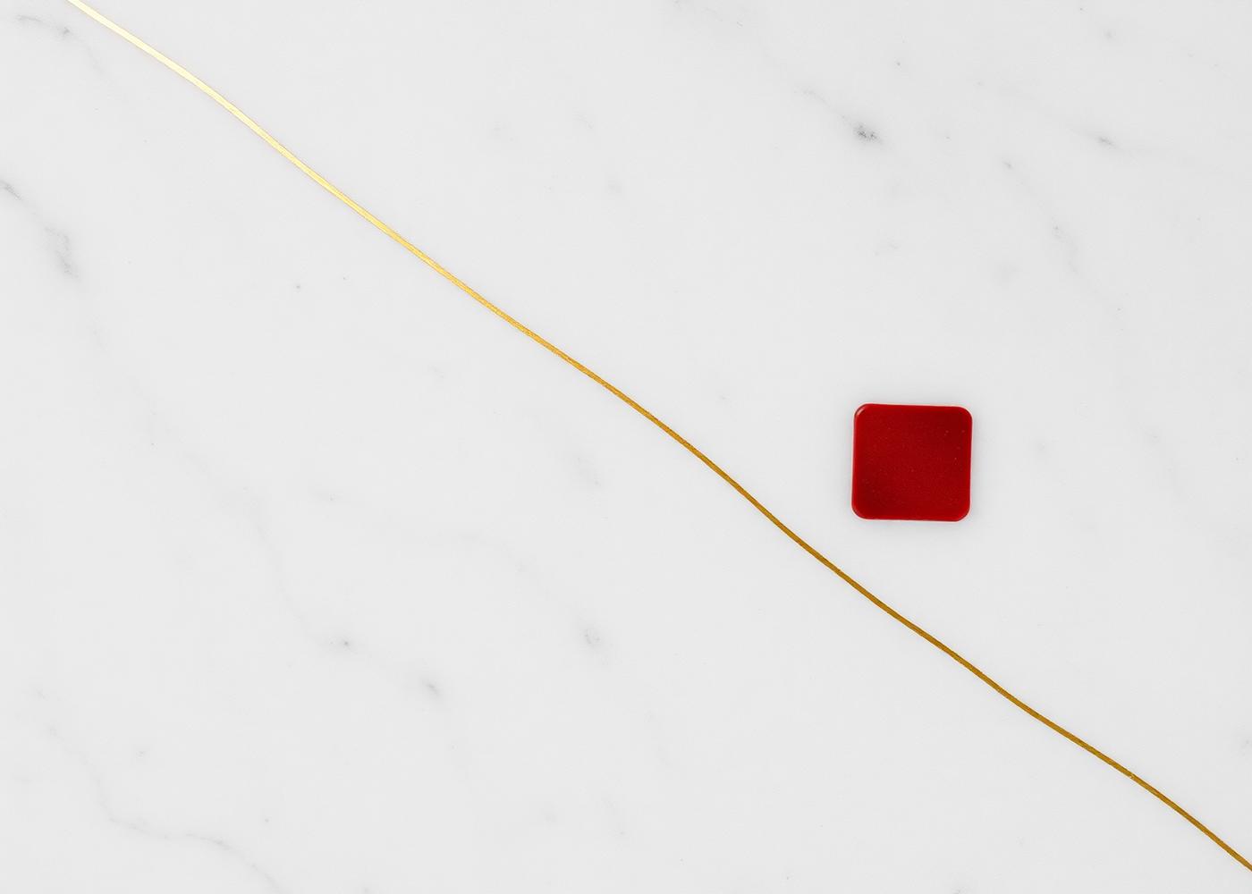 Marble surface with gold rule and red seal — symbolizing precision and trust